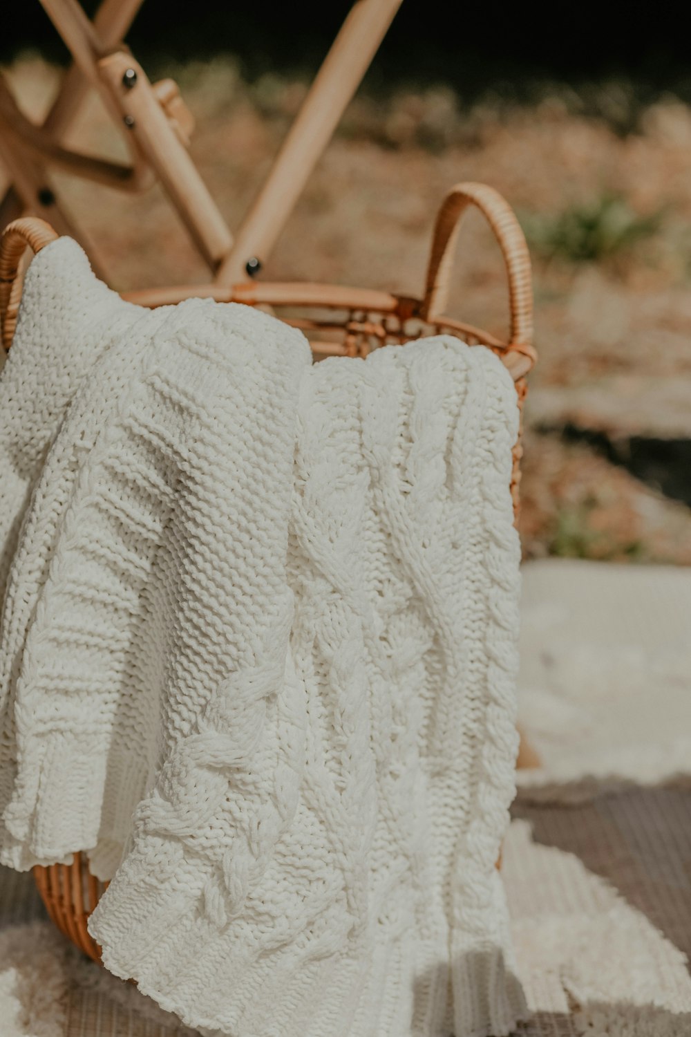 a white blanket sitting on top of a wooden chair