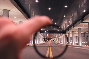 a hand holding a magnifying glass over a street