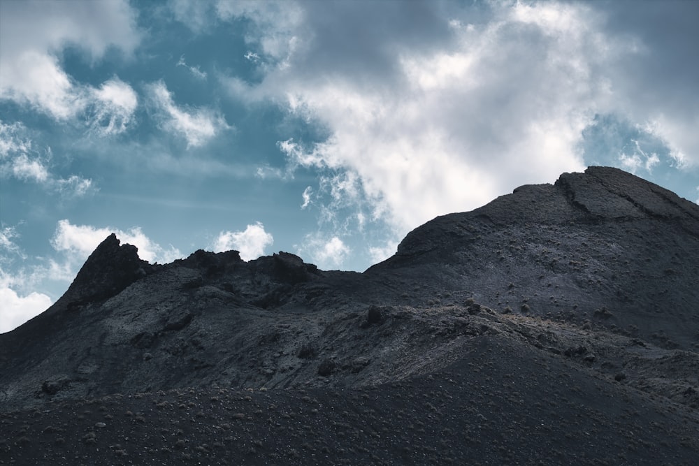 a very tall mountain with some clouds in the sky