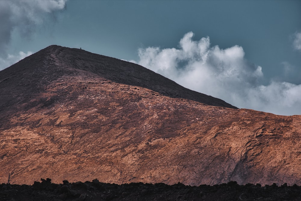 a very tall mountain with a sky in the background