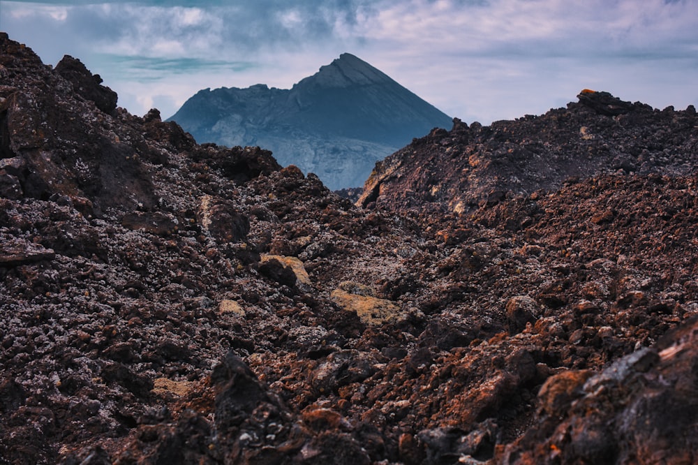 a rocky mountain with a mountain in the background