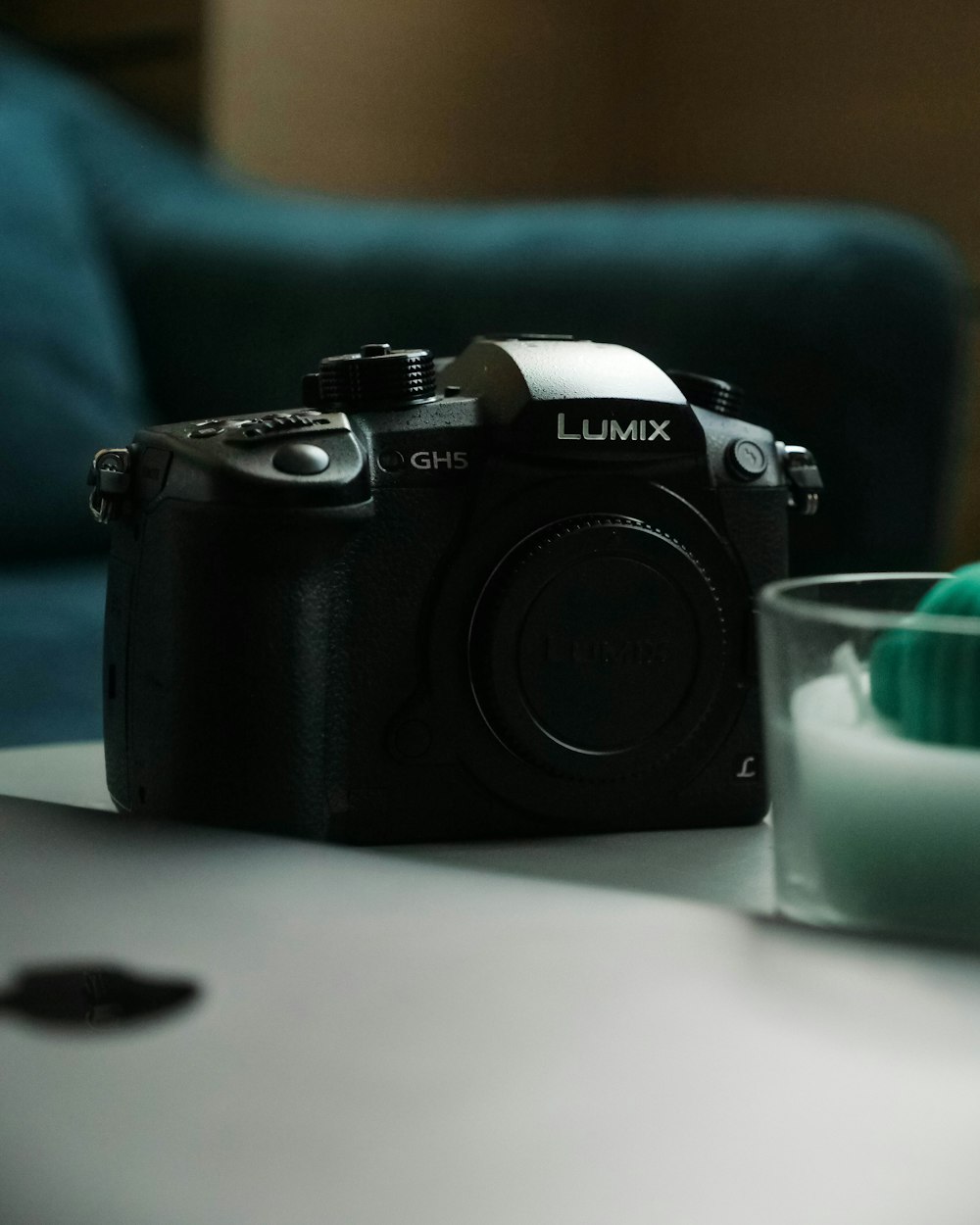 a camera sitting on top of a table next to a glass