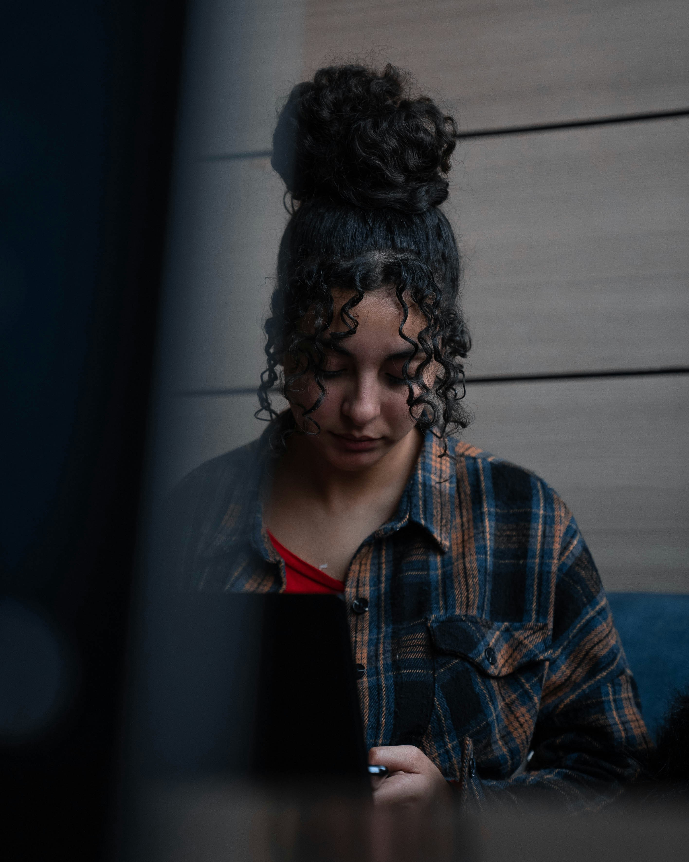 a woman sitting at a table looking at her cell phone
