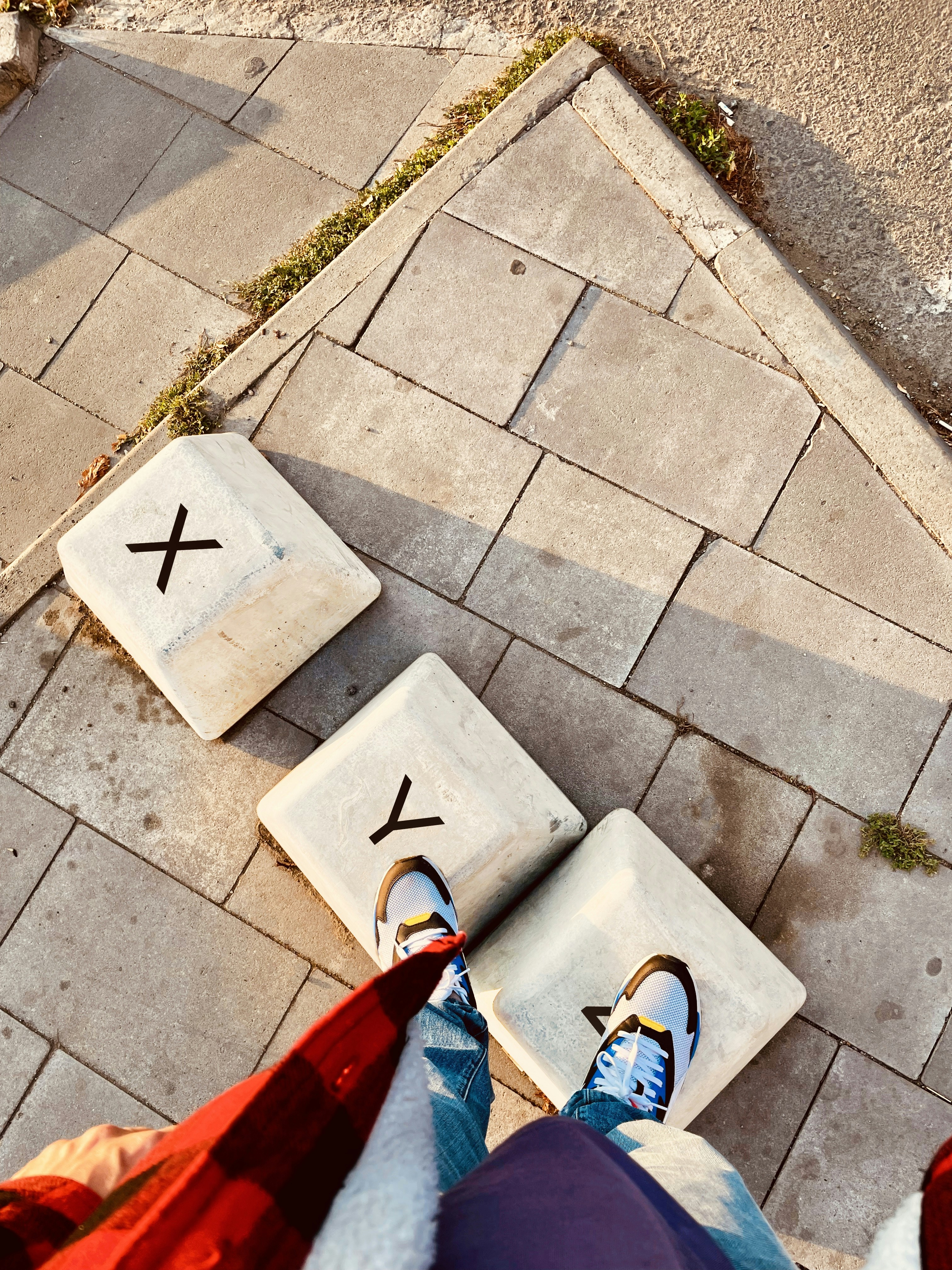 Una persona parada en una acera junto a una señal de cruce de peatones