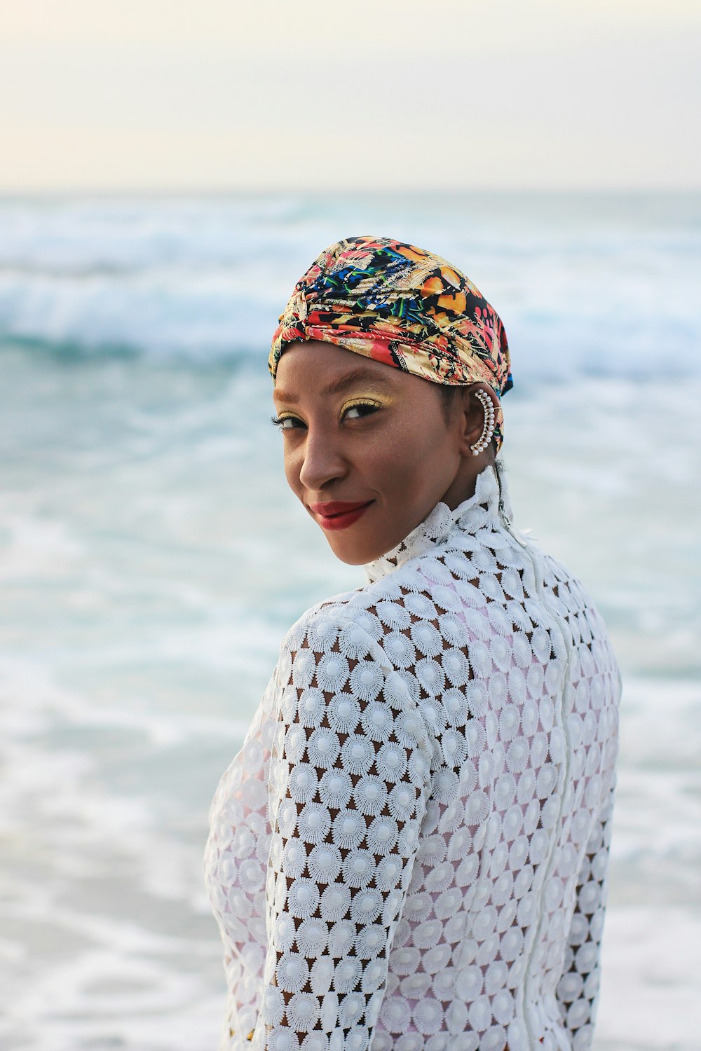 a woman standing on a beach next to the ocean