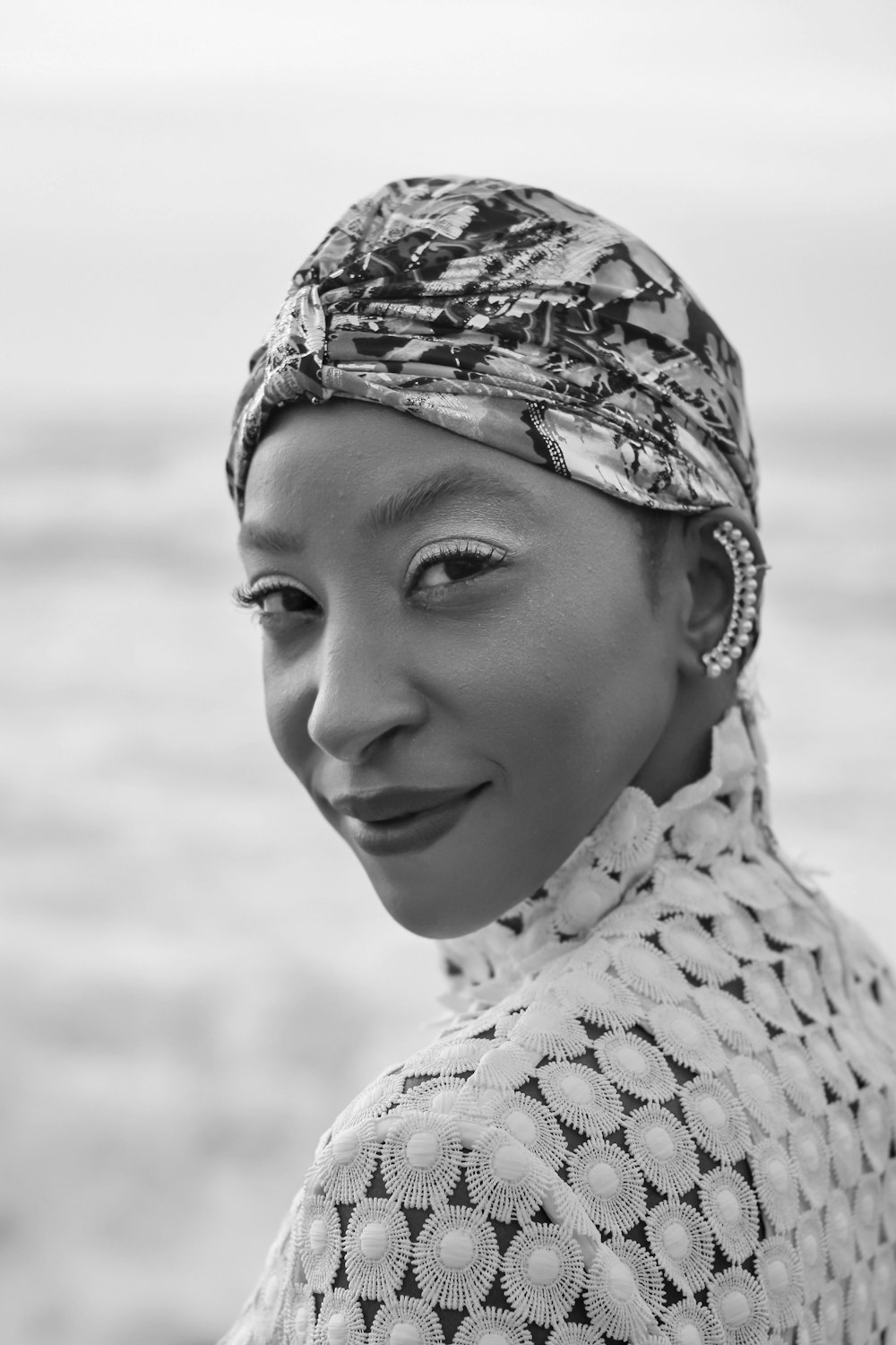 Une femme avec un foulard et un sourire sur son visage