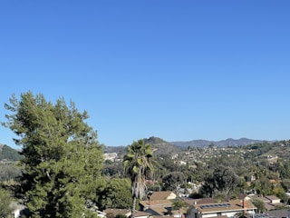 A panoramic view of available residential lots surrounded by lush greenery and clear skies.