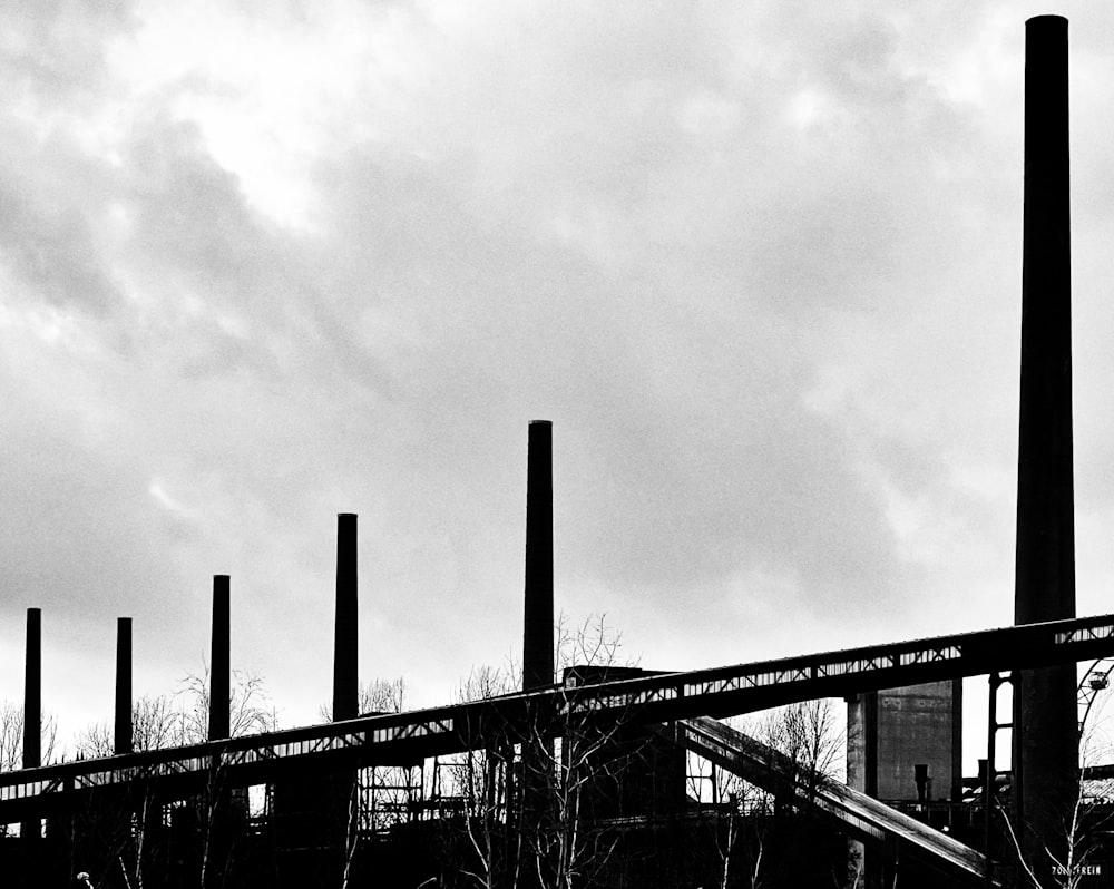 a black and white photo of a factory with smoke stacks