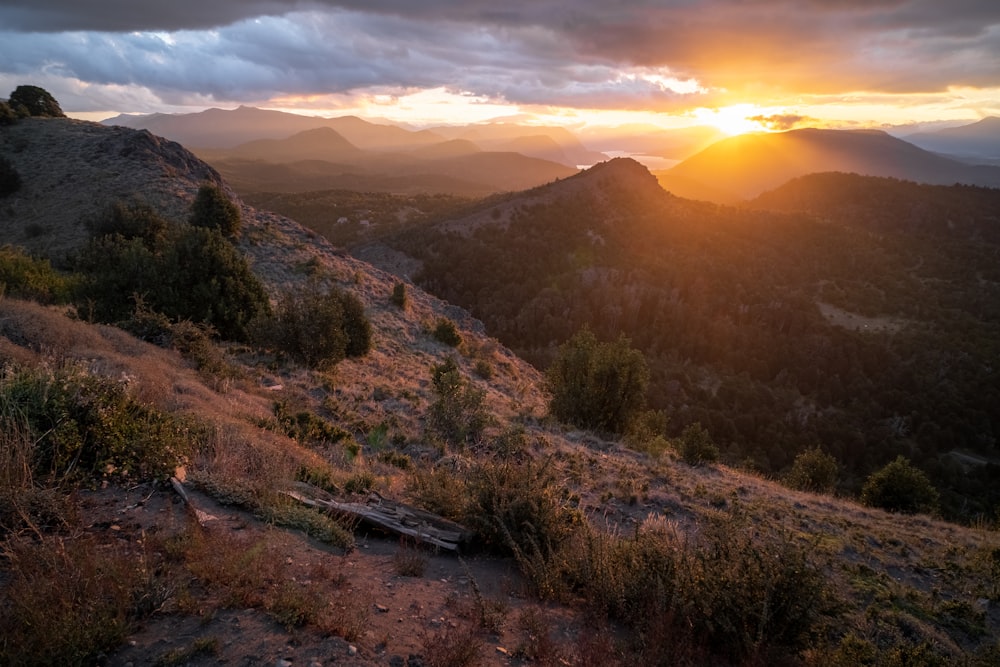 the sun is setting over a mountain range