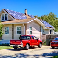 a red pick up truck parked in front of a house