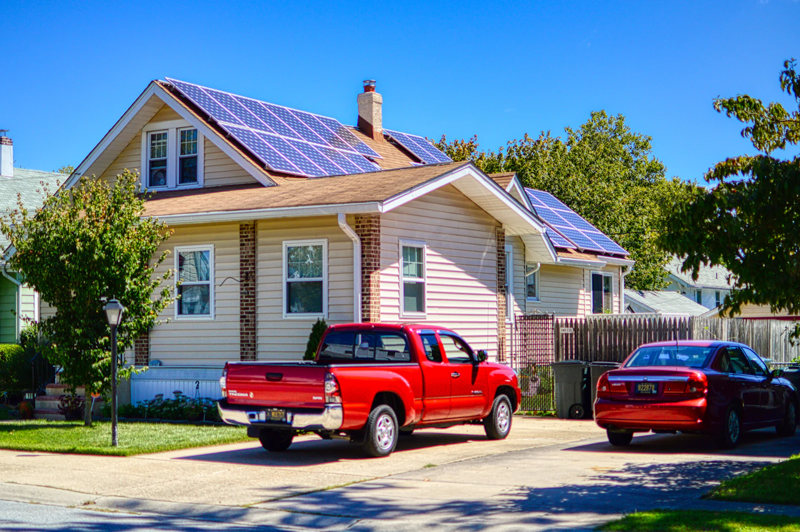 House with solar panels on the roof and a truck parked out front