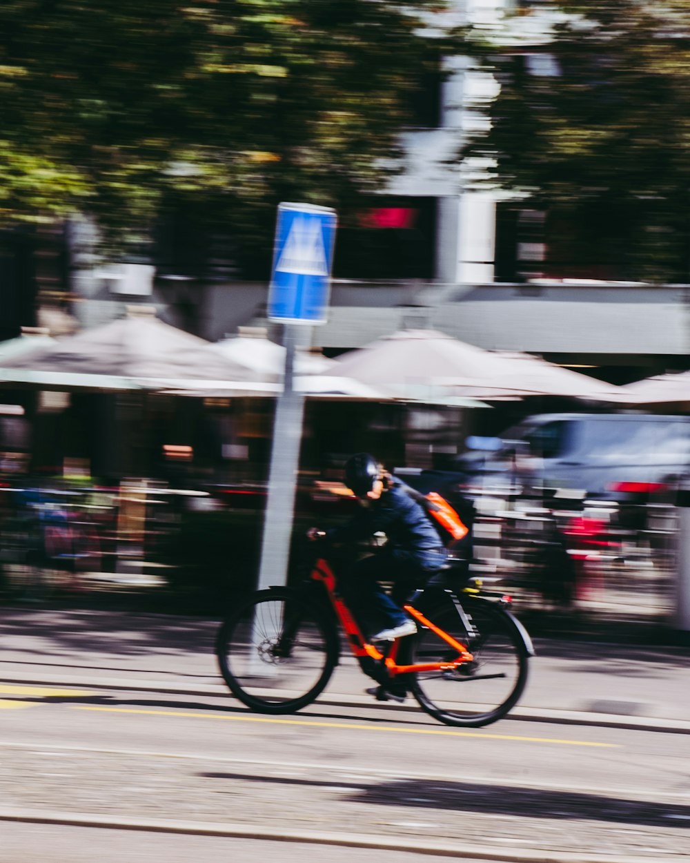 Un homme à vélo dans une rue à côté d’un panneau de signalisation
