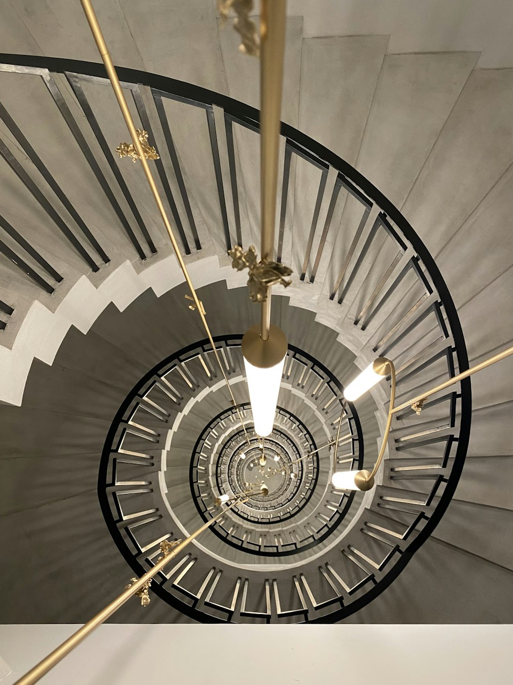 a spiral staircase with a chandelier hanging from the ceiling