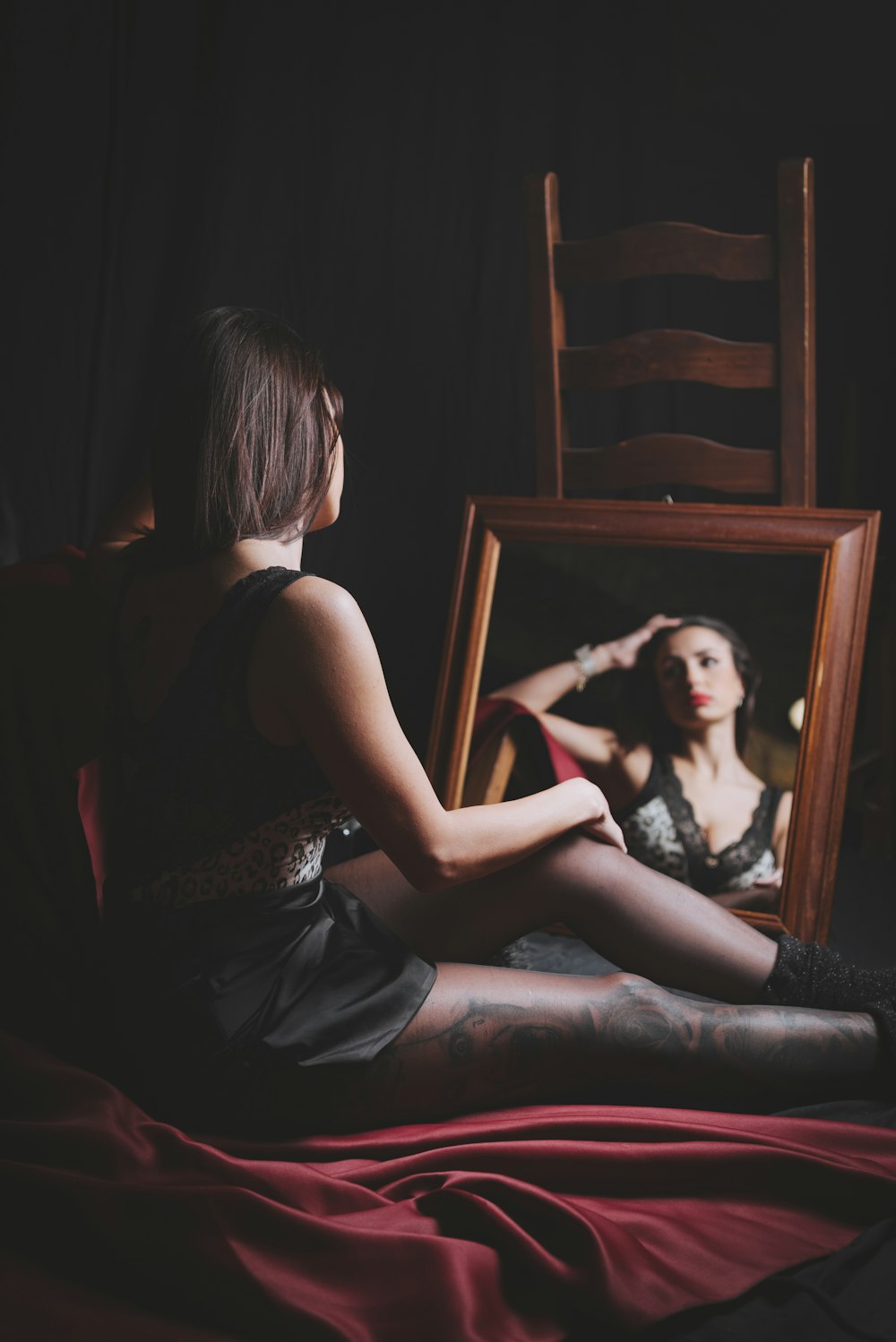 a woman sitting on a bed in front of a mirror
