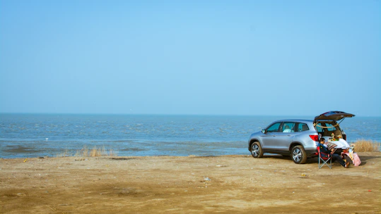 A happy family loading luggage into a spacious rental SUV near the beach.