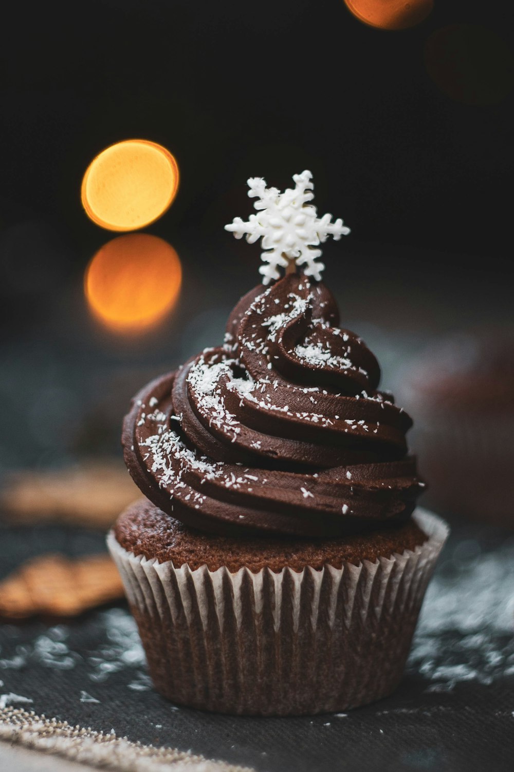 a cupcake with chocolate frosting and a snowflake on top