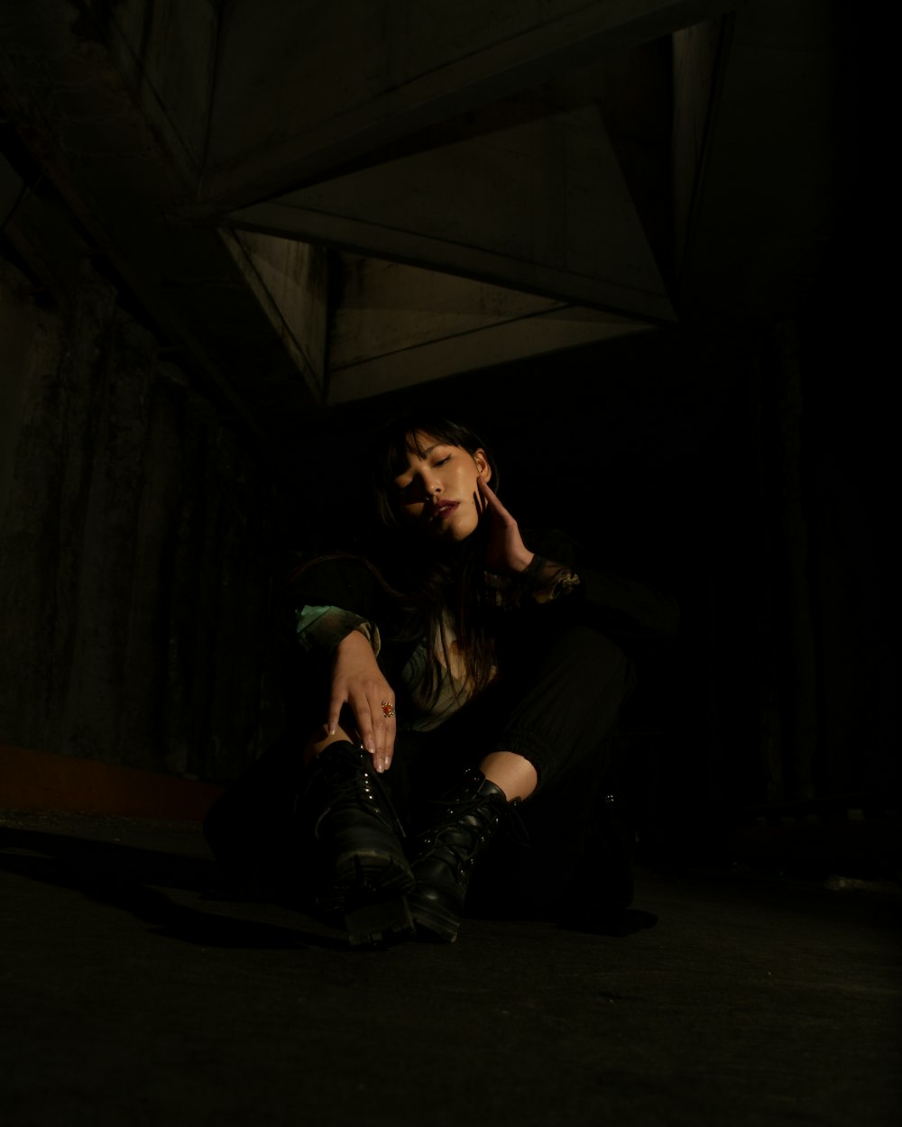 a woman sitting on the ground in the dark