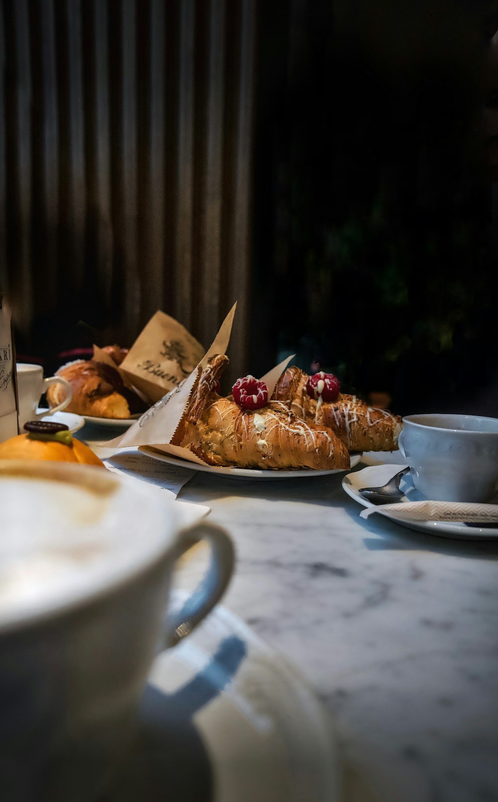 a table topped with plates of food and cups of coffee