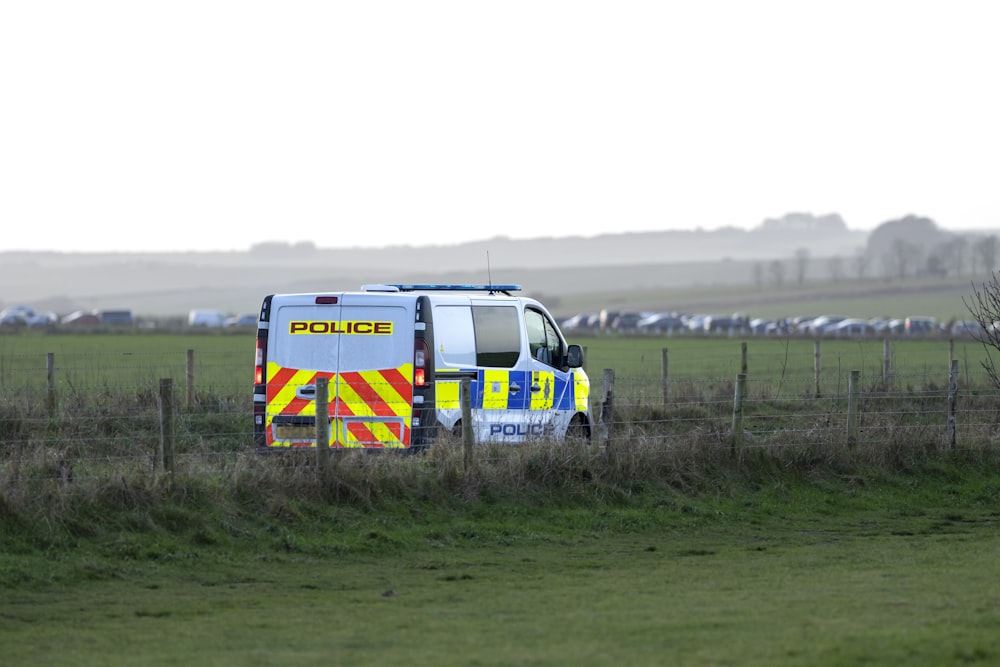 a police van parked in a field behind a fence
