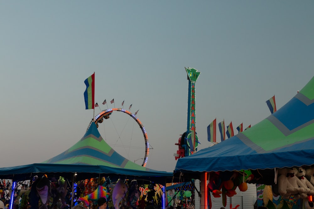 a carnival with a ferris wheel in the background