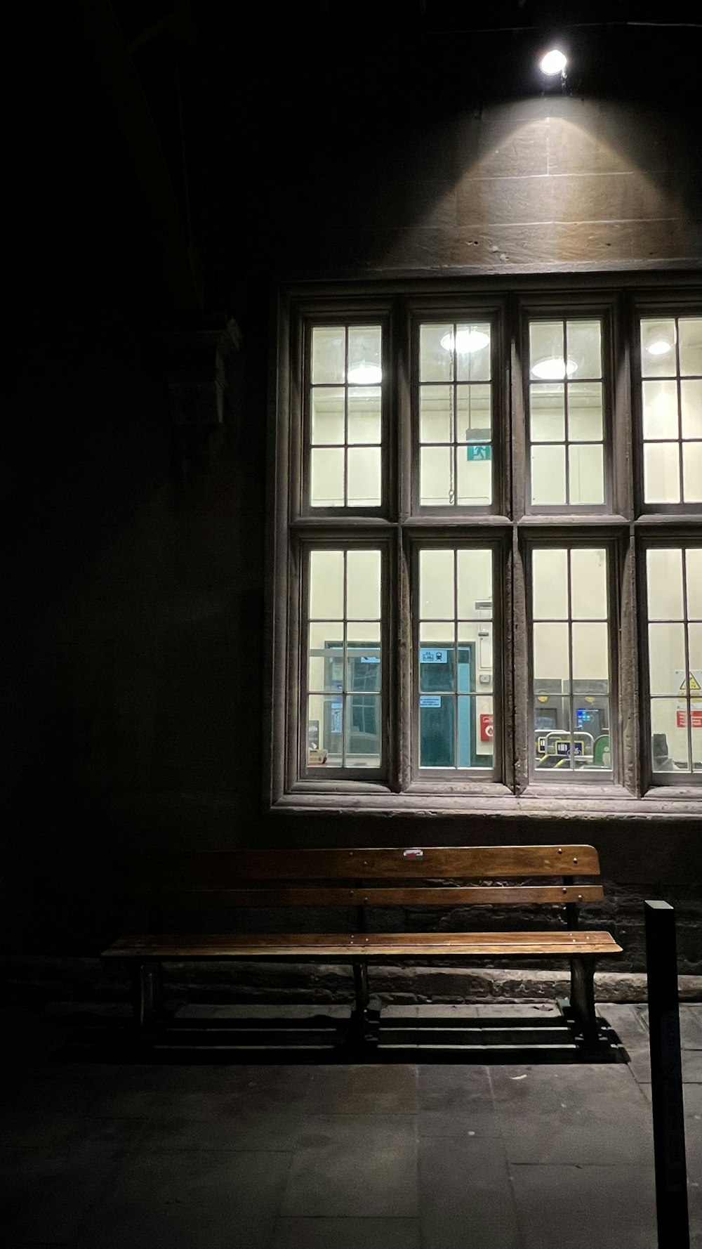 a bench sitting in front of a window in a dark room