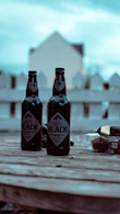 three bottles of beer sitting on top of a wooden table