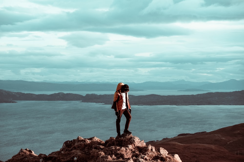 Una persona parada en la cima de una colina rocosa
