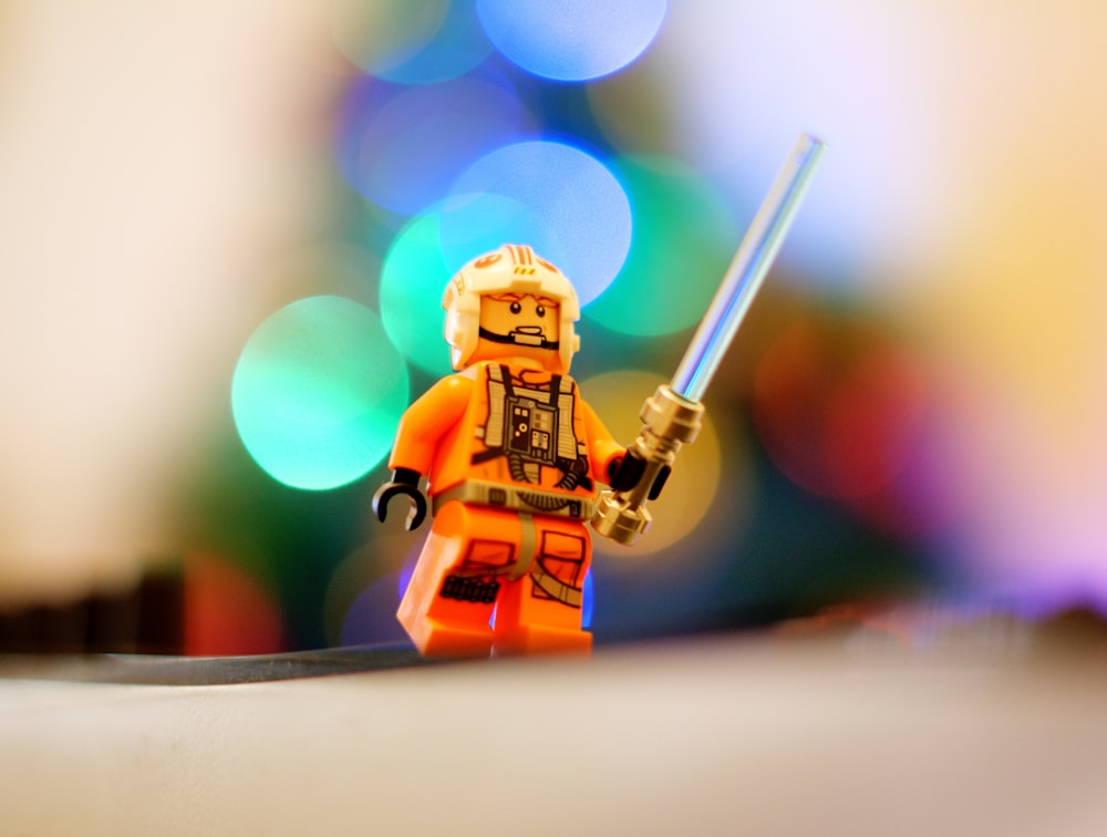 a lego star wars character holding a light saber