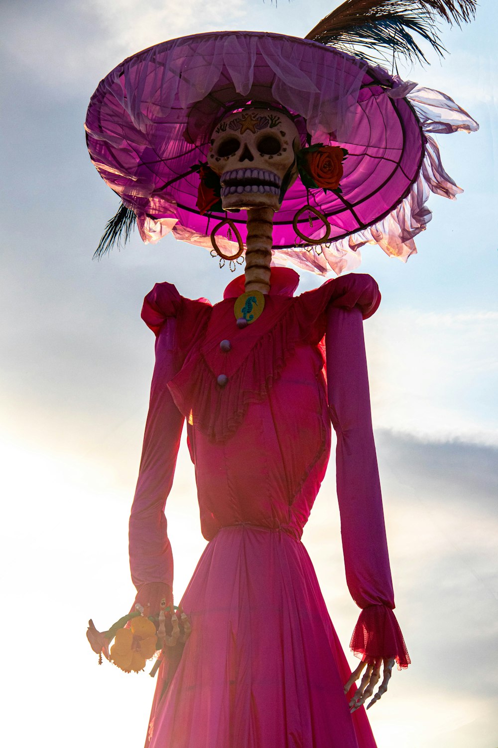 a skeleton wearing a pink dress and hat
