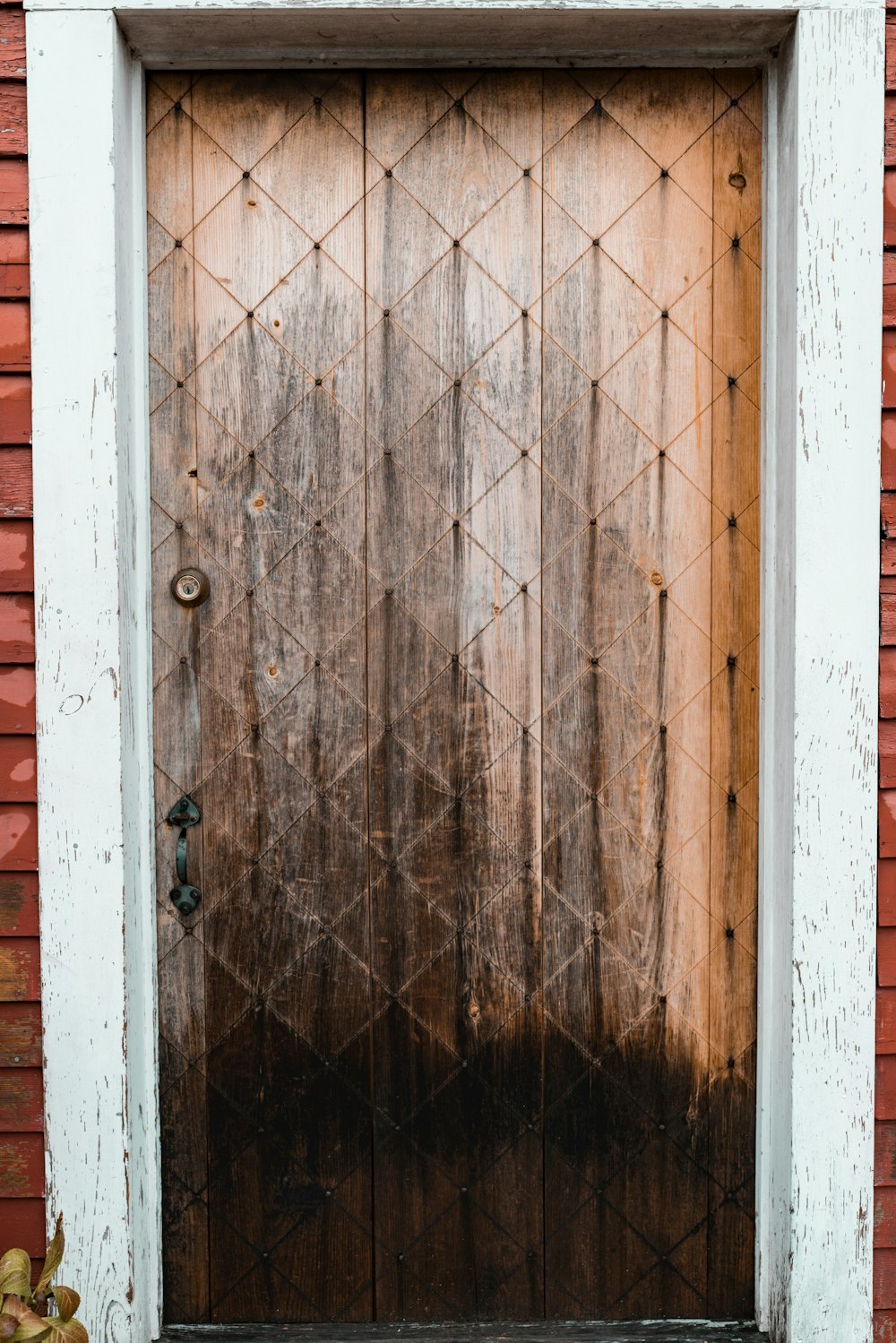 a wooden door with a brick wall behind it