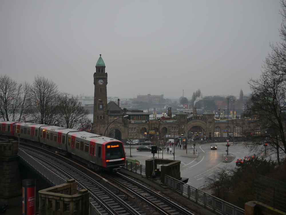 Ein Zug auf einer Bahnstrecke mit einem Glockenturm im Hintergrund