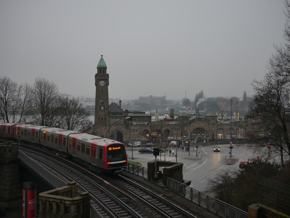 a train on a train track with a clock tower in the background