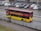 a yellow and red double decker bus driving down a street