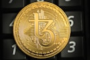 a gold coin sitting on top of a computer keyboard