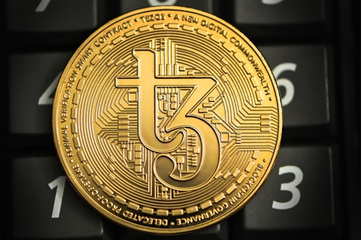 a gold coin sitting on top of a computer keyboard
