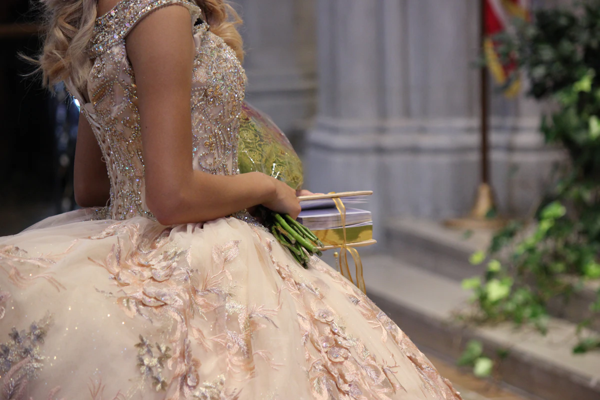 Young woman in a ball gown holding a bouquet of flowers