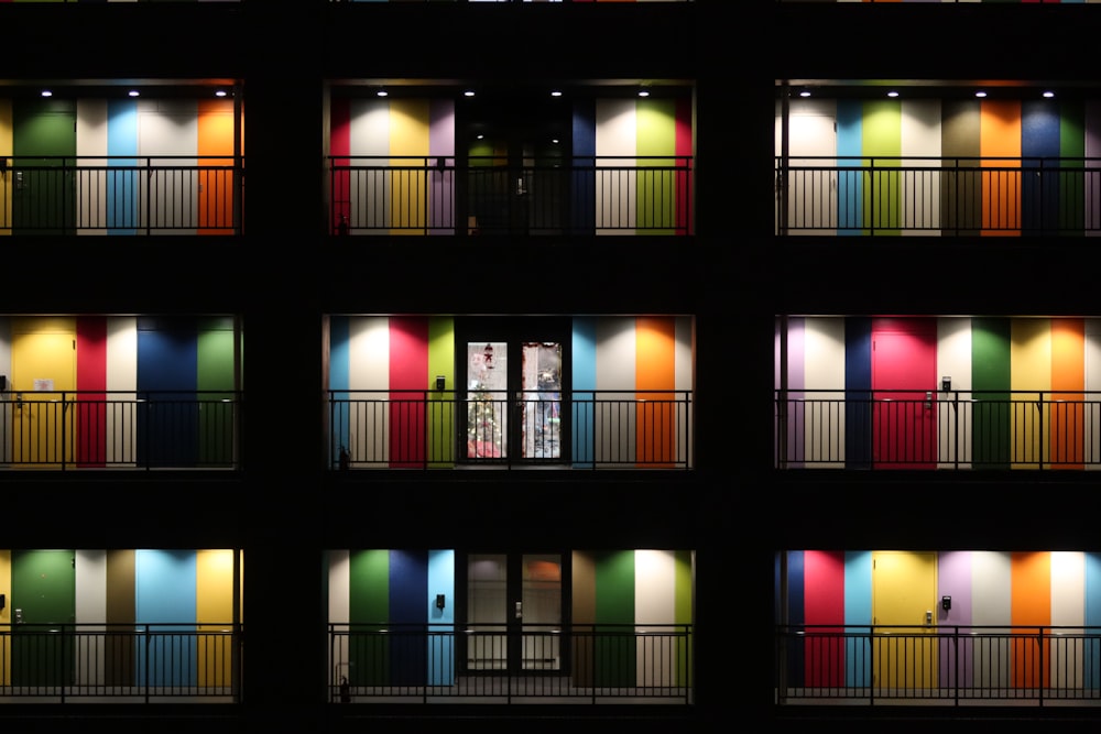 a multicolored building is lit up at night