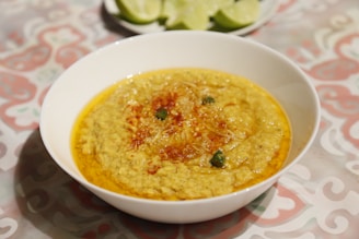 Freshly baked Arabic breads stacked beside steaming bowls of hearty lentil soup.