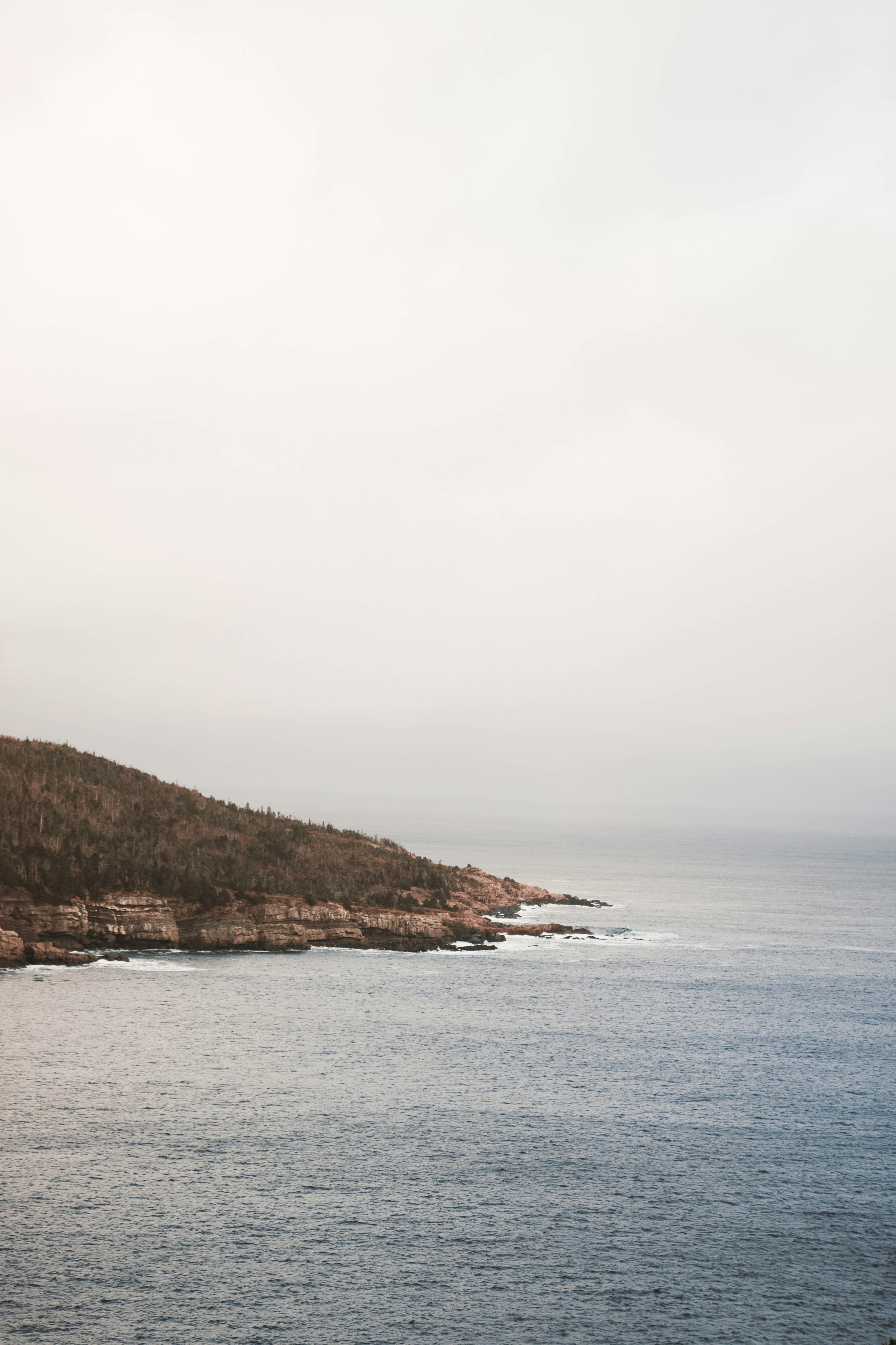 a body of water with a hill in the background