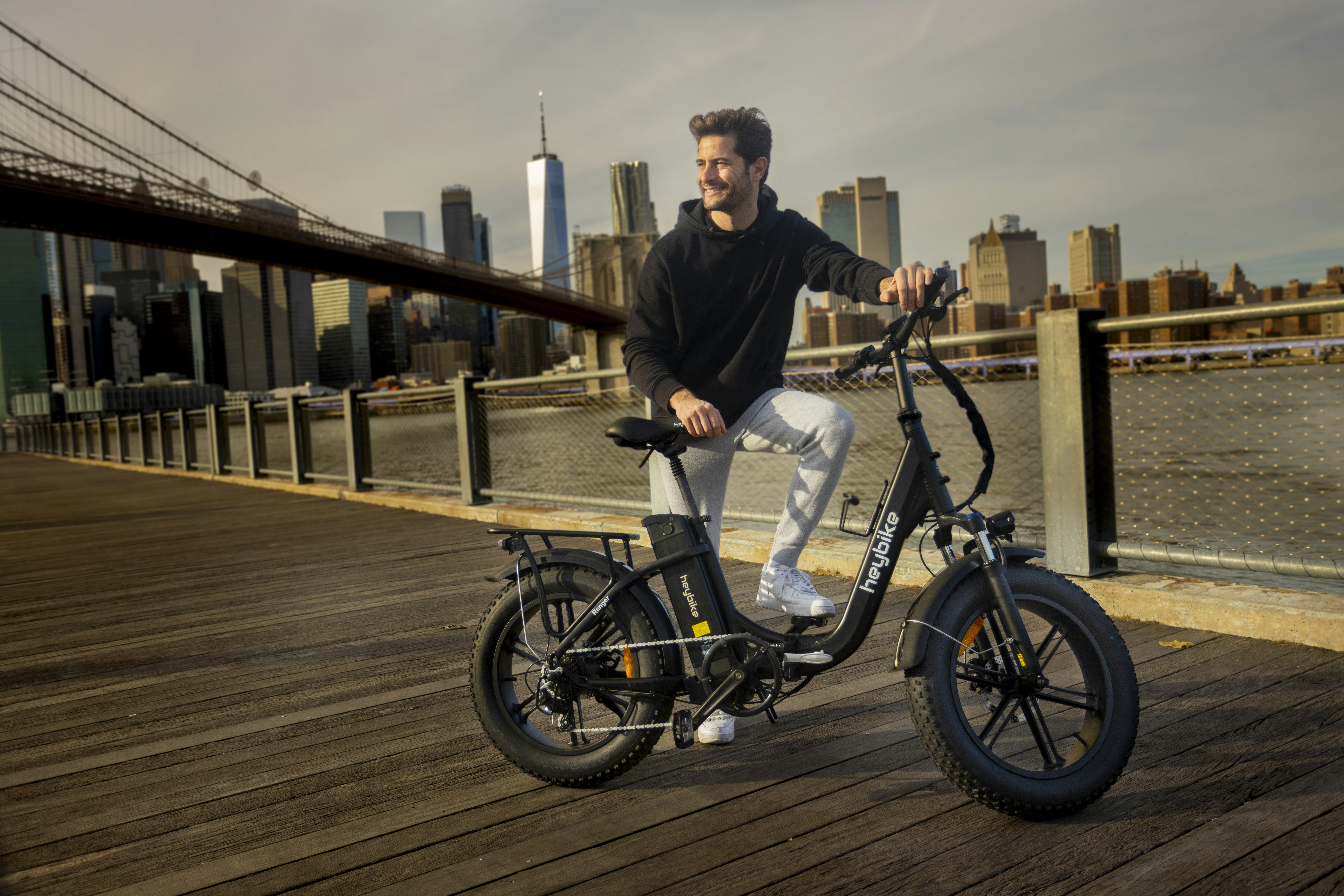 a man sitting on a bike on a bridge