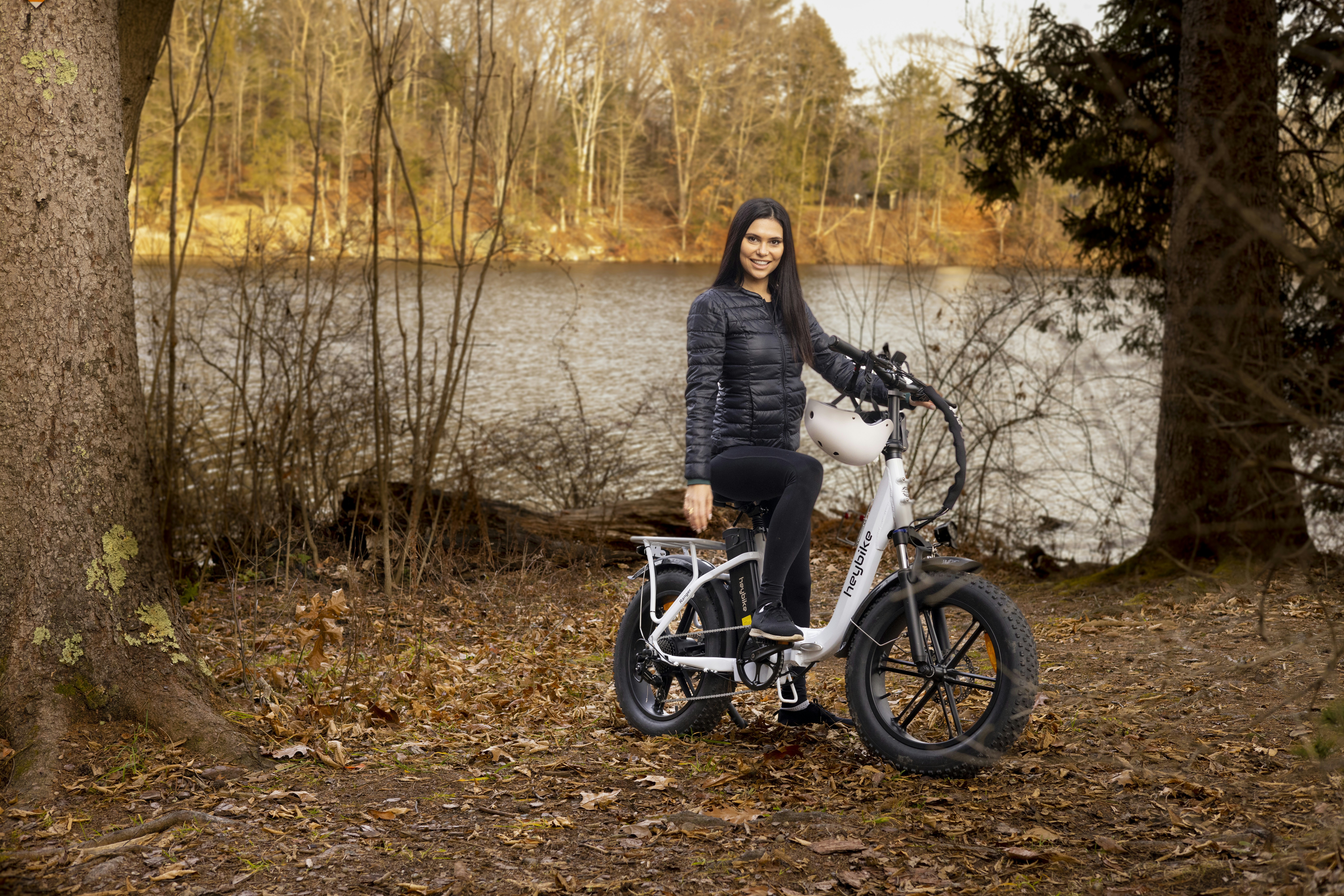 a woman standing next to a bike in the woods