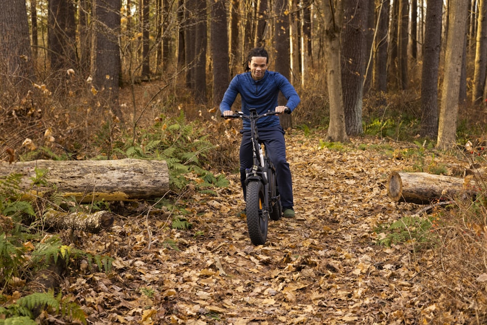 a man riding a bike through a forest