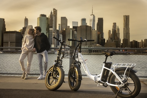 a man and a woman standing next to a bike