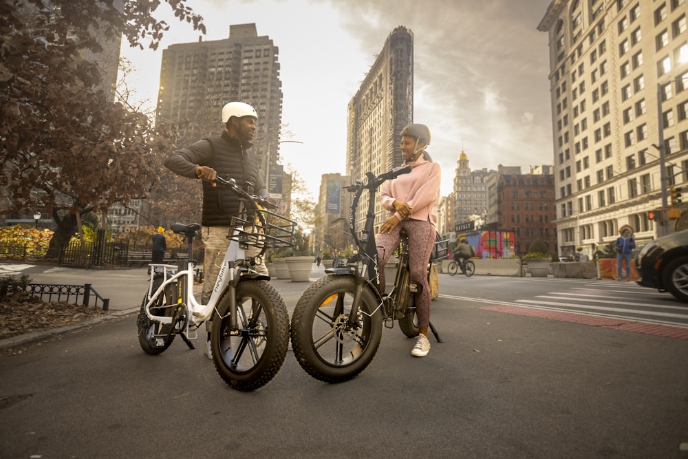 a man and a woman standing next to their bikes