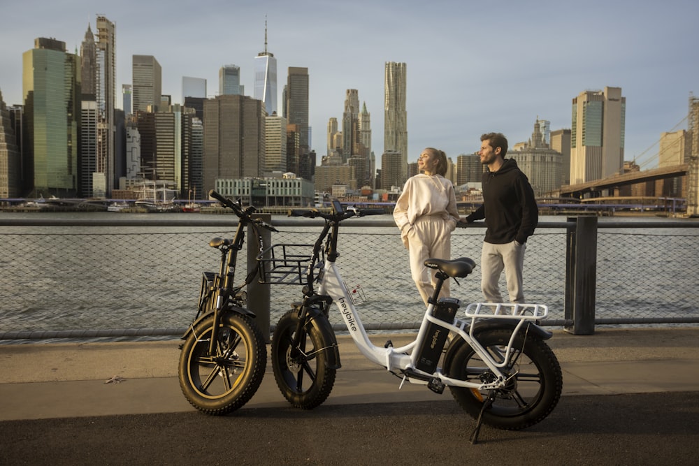 a man and a woman standing next to a bike