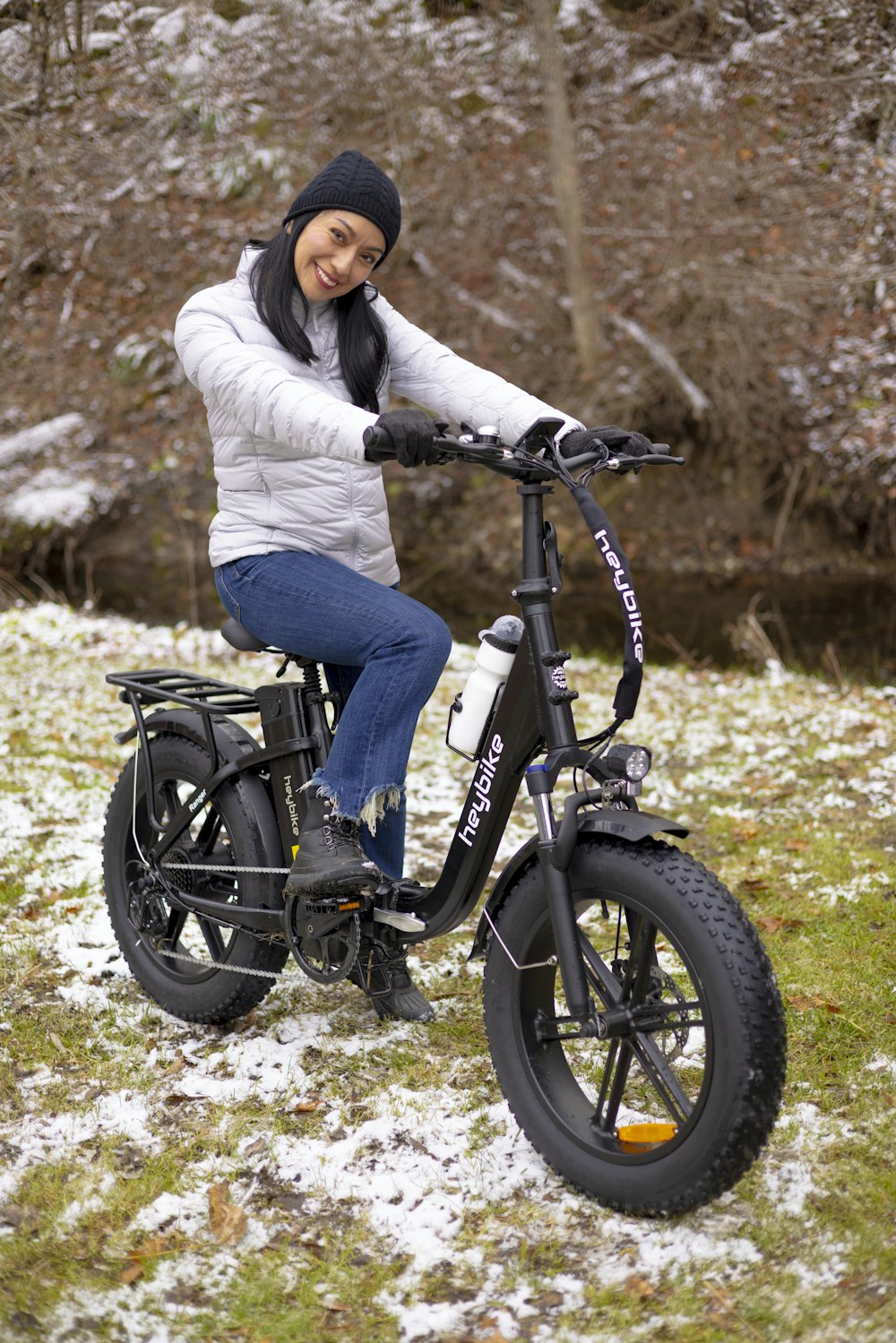 a woman sitting on top of a bike in the snow