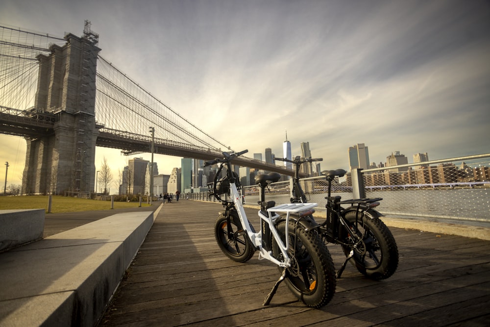 two bikes parked next to each other in front of a bridge