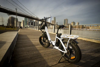 A sleek ebike parked with the Times Square lights glowing in the background at dusk.