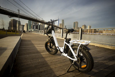 A sleek ebike parked with the Times Square lights glowing in the background at dusk.