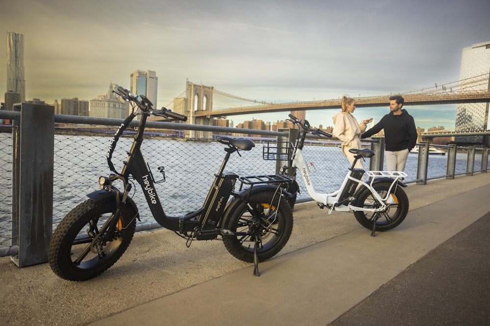 a couple of people standing next to a parked bike